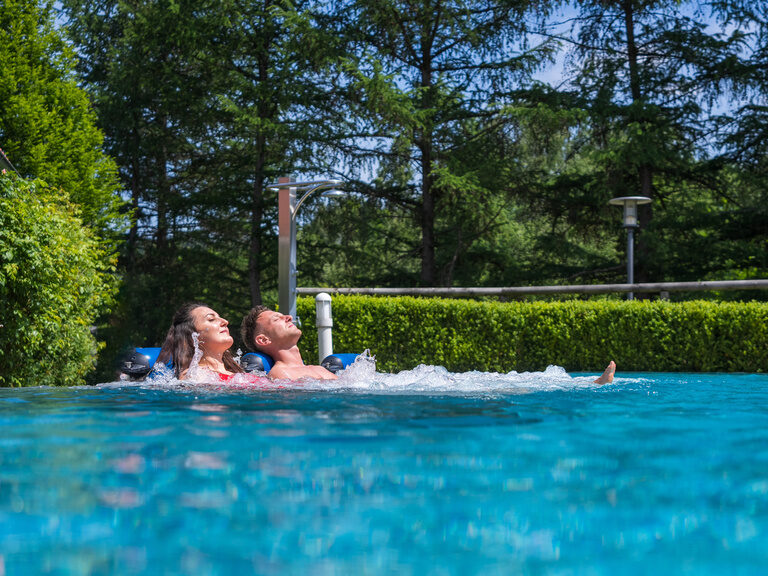 Ein Paar entspannt im Aussenpool